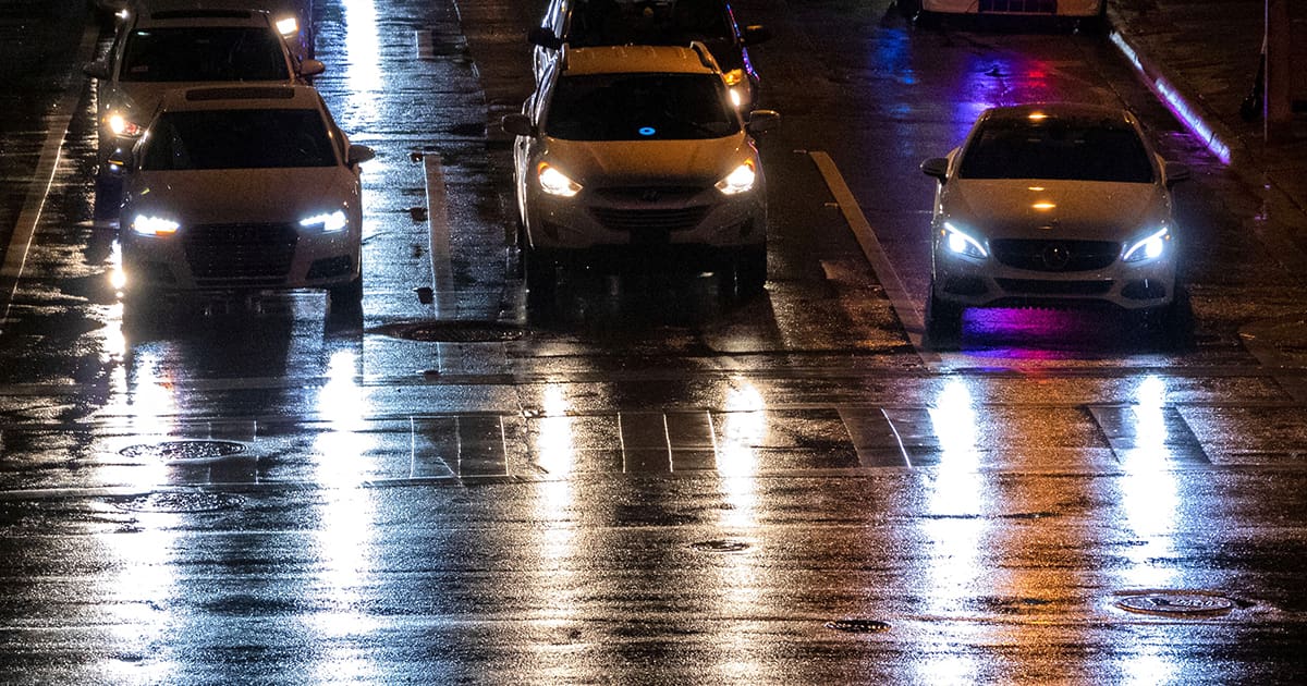 Late night drive through city with reflections of headlights